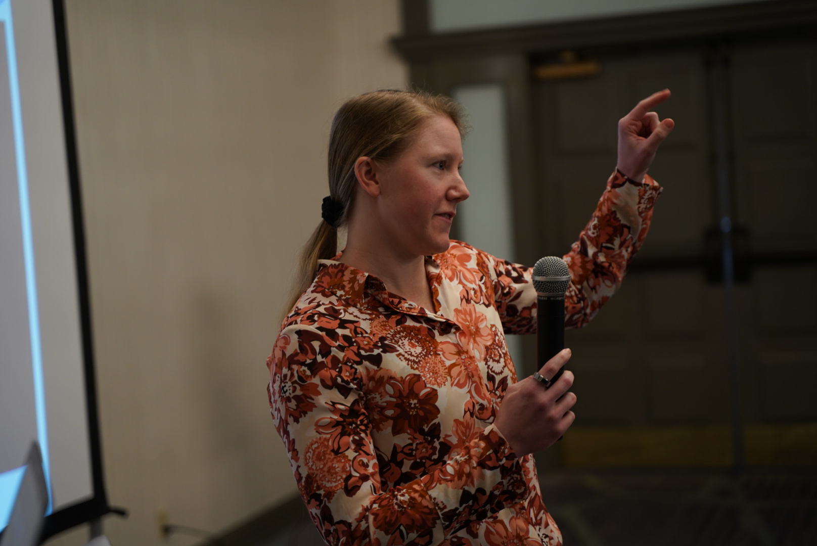 Dr. Laura Buchanan speaking with a microphone