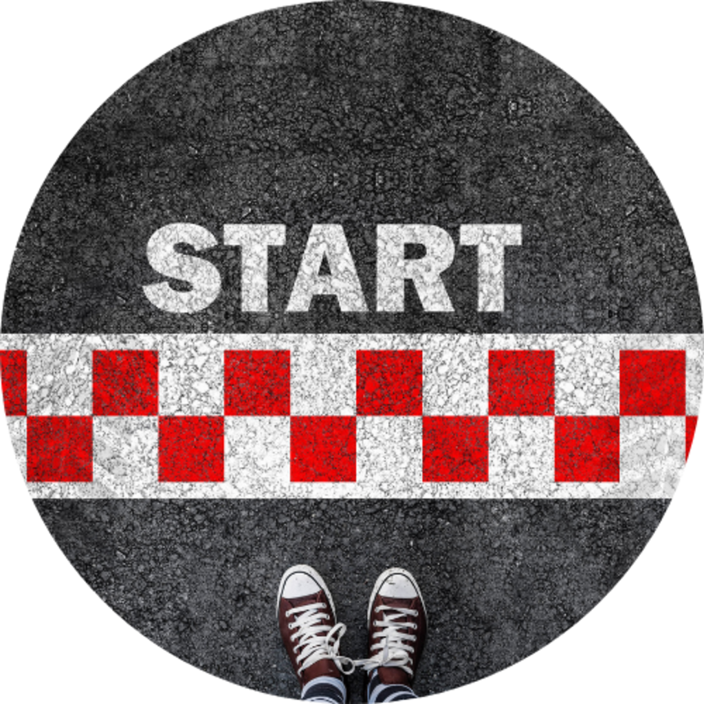 Runner's viewpoint at the start line: the word START over a red and white checker stripe across a road edge.