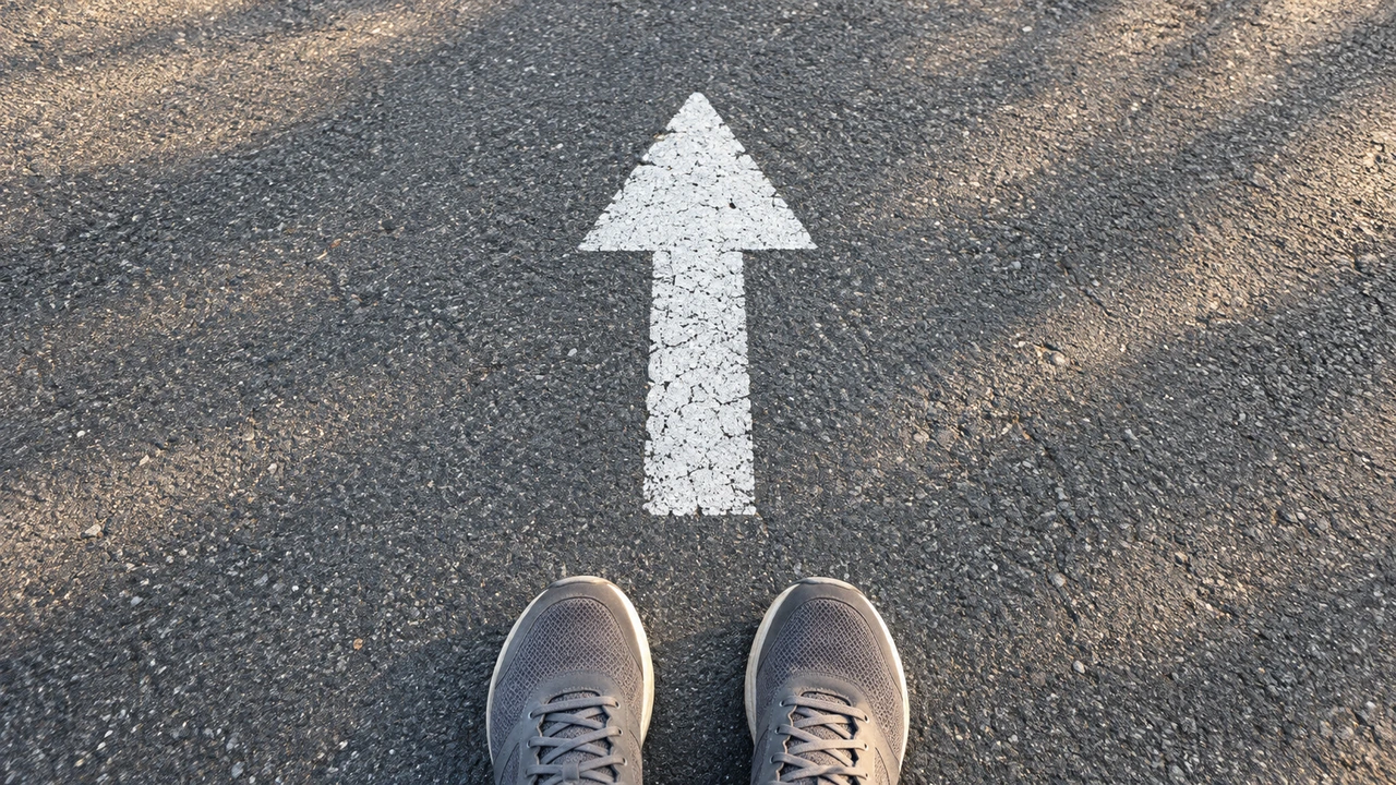 Walking shoes at a painted arrow on a path.