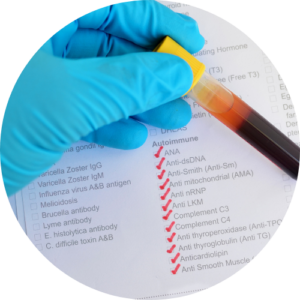Gloved hand using a yellow pipette to transfer a blood sample onto a medical checklist with red checkmarks on the page